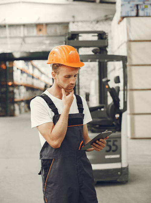 Uomo che lavora in magazzino con casco e radio, durante operazioni logistiche